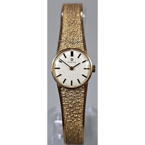 457 - 9ct gold Omega bracelet wristwatch, having circular satin face with Baton numerals on a bark finish ... 