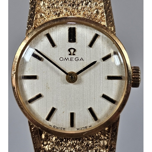 457 - 9ct gold Omega bracelet wristwatch, having circular satin face with Baton numerals on a bark finish ... 