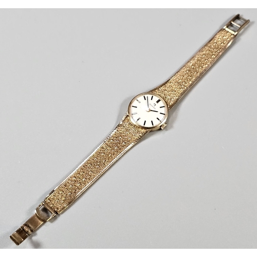 457 - 9ct gold Omega bracelet wristwatch, having circular satin face with Baton numerals on a bark finish ... 