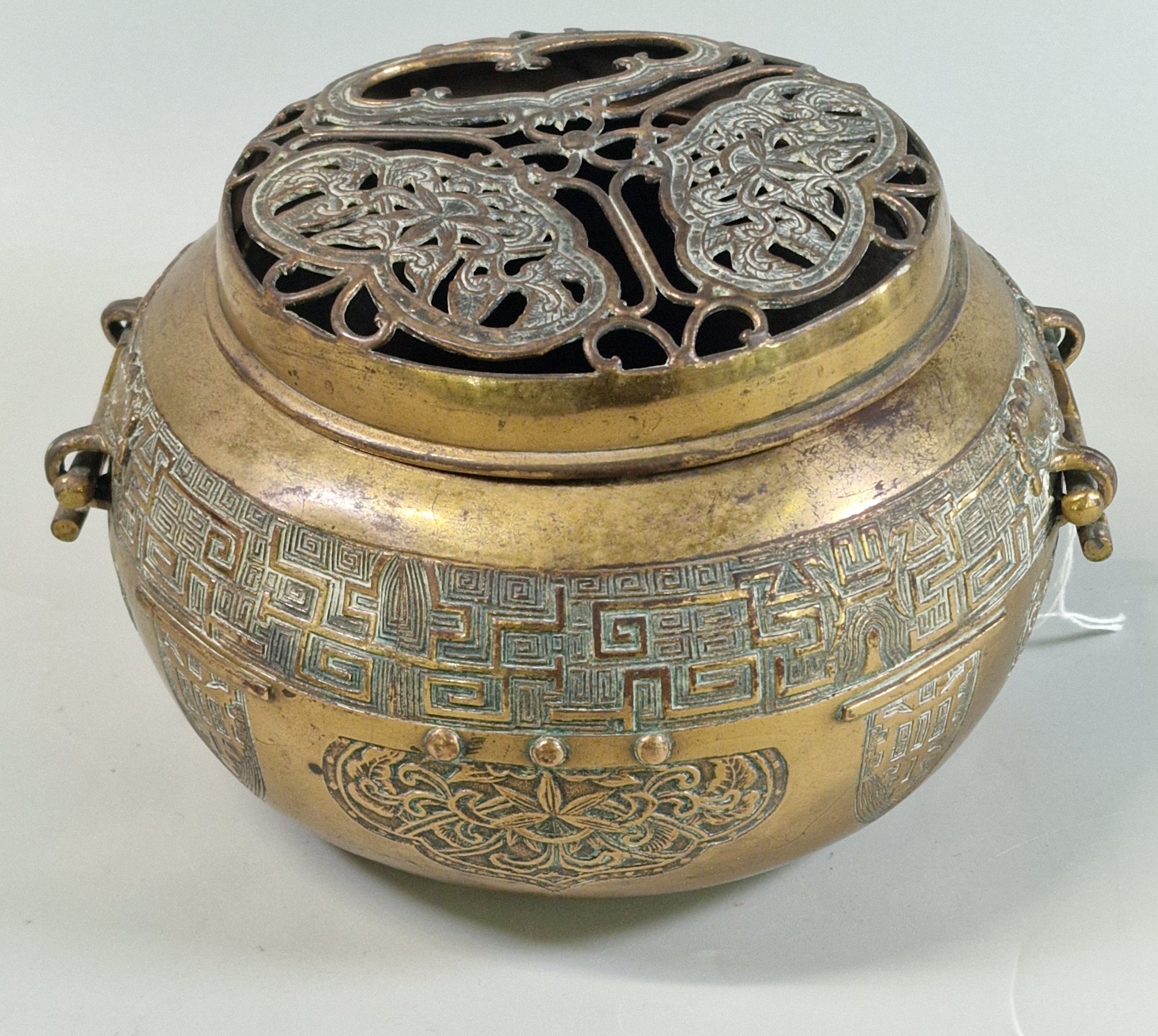 A Chinese brass twin-handled censer with archaic style banding around ...