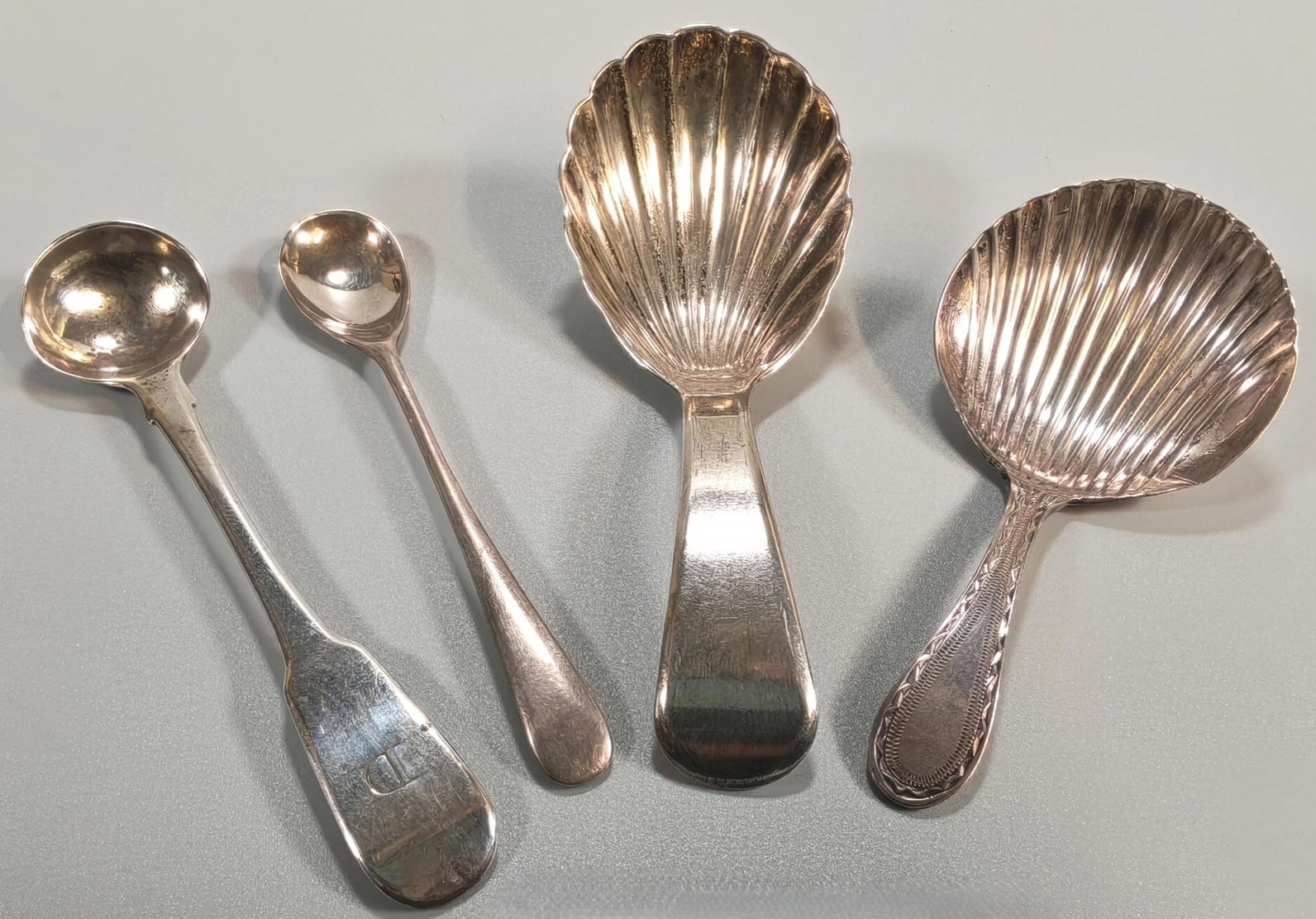 Two silver shell shaped caddy spoons, together with another two salt ...