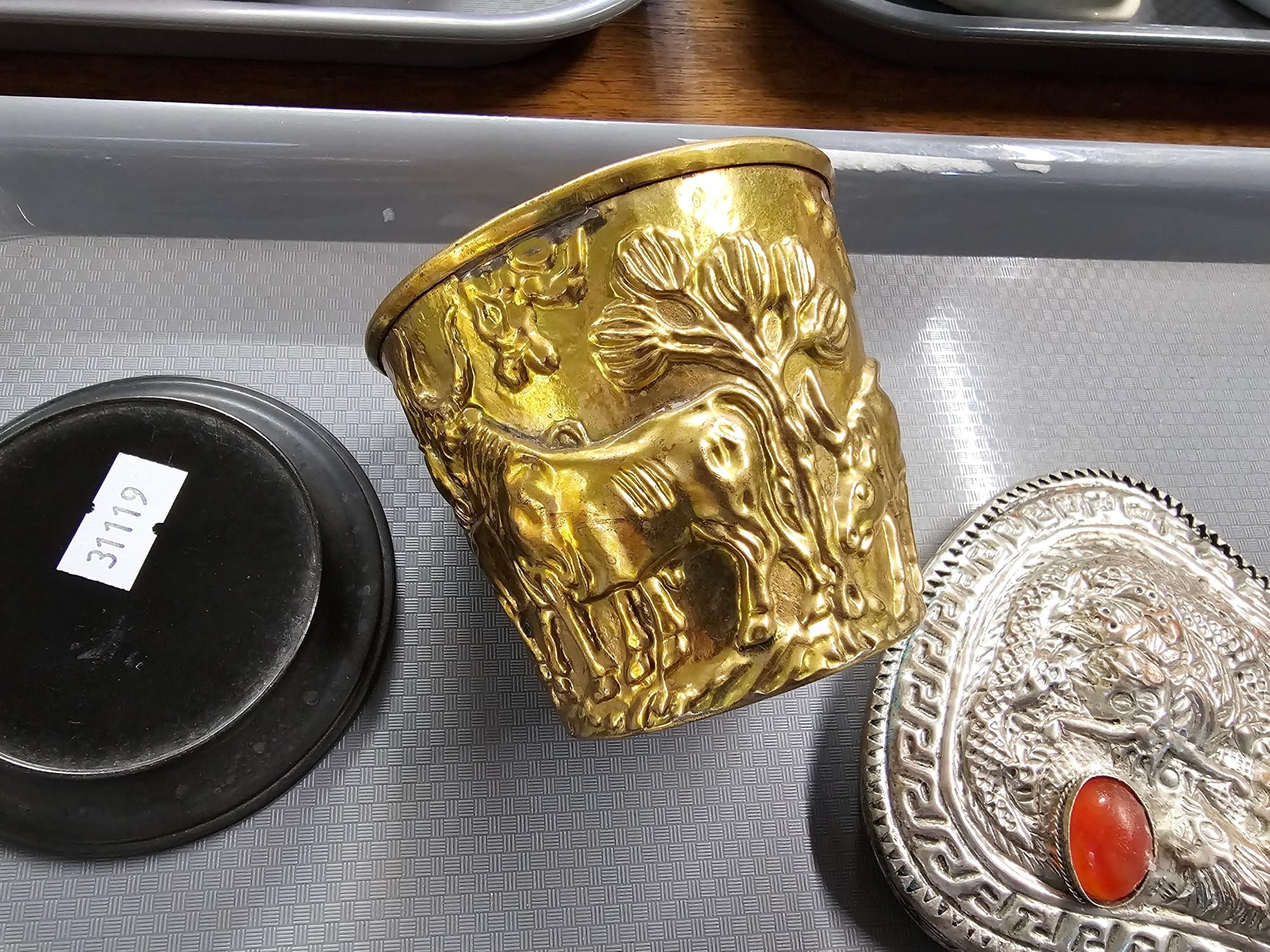 Collection of items to include: animal repoussé decorated cup on stand ...