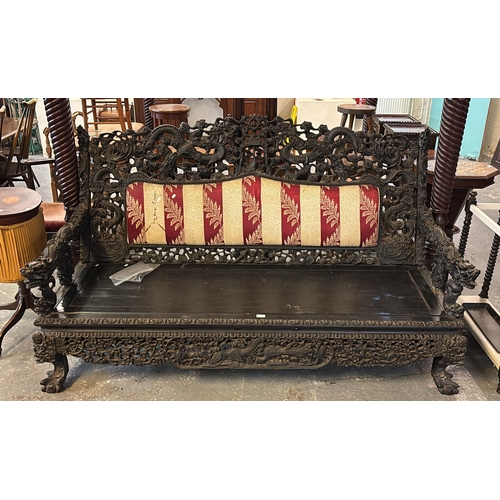 768 - 19th century heavily carved, stained and pierced Chinese sofa, overall decorated with entwined drago...
