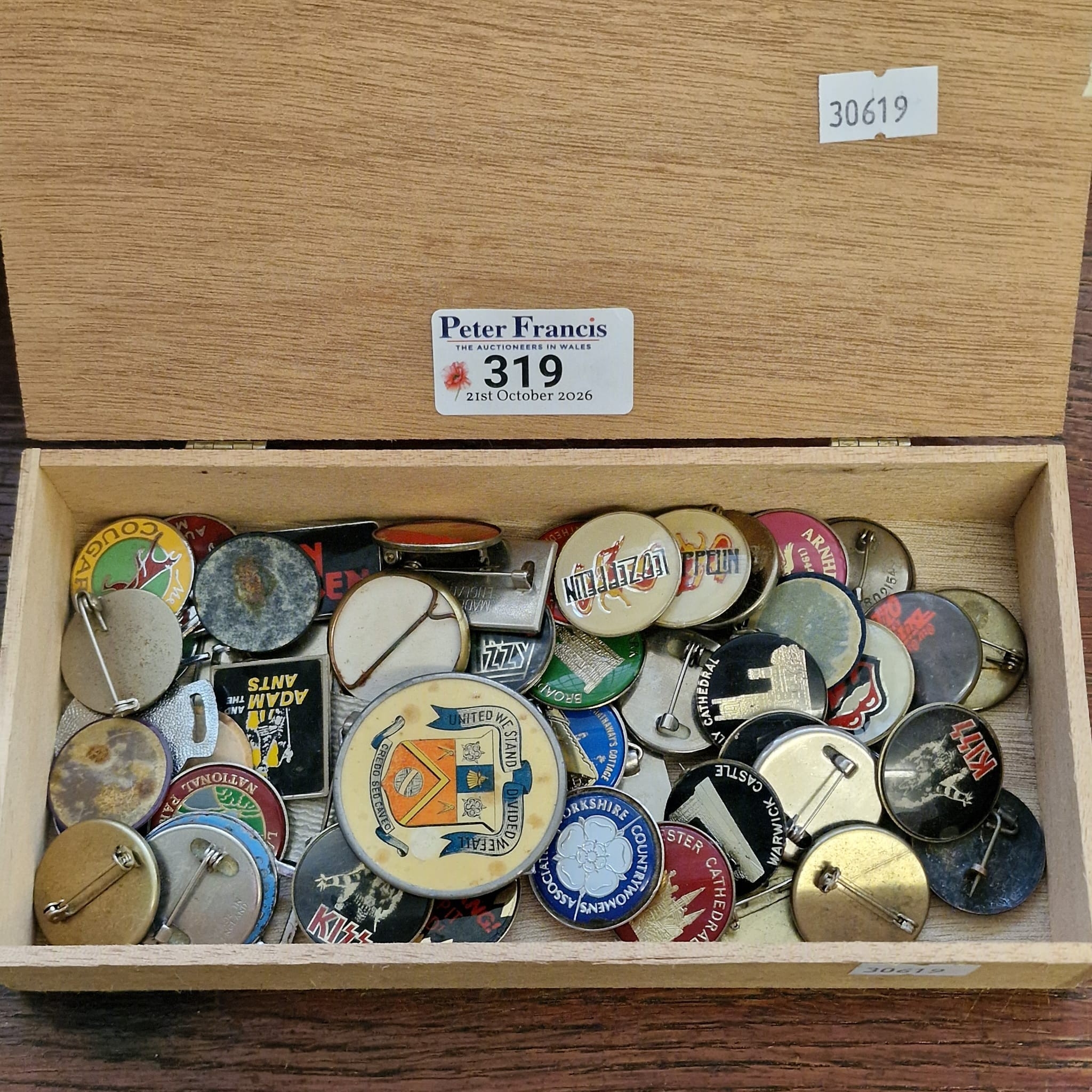 Cigar box comprising assorted badges to include: various music groups ...