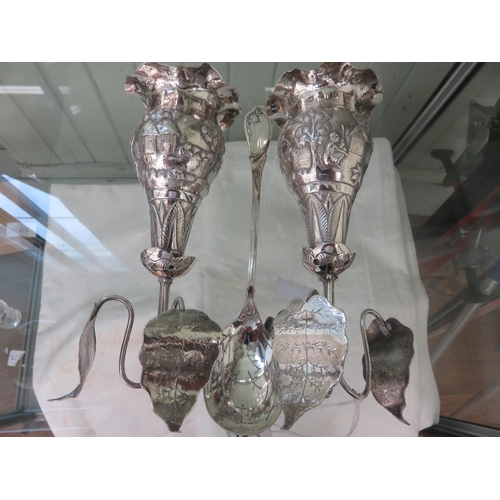 258 - Pair of Embossed Indian Silver Holders and an odd plated spoon