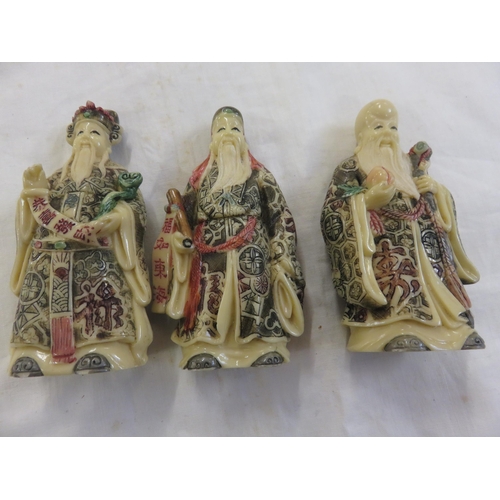 206 - Three Oriental Resin figures on hardwood stands