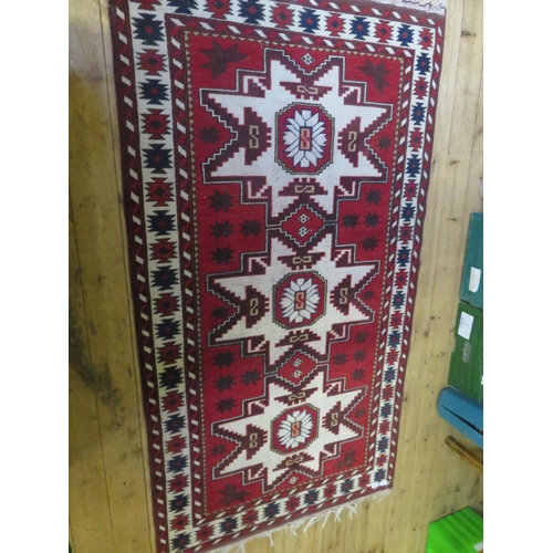 470 - Fringed rug on red ground - three centre medallions 74