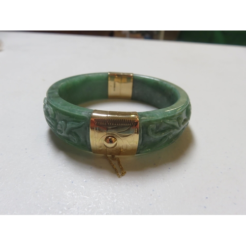 106 - 14ct Gold Mounted Carved Jade Bangle