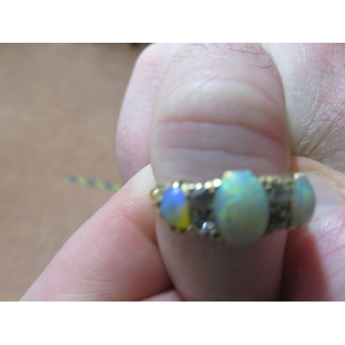 72 - Yellow Metal Ring with three opal stones and four white stones