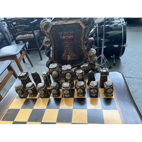 650 - Ornately carved chess table and 'Knight' chairs