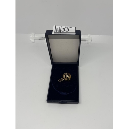 33 - 9ct Gold Albert charm featuring a tiger's eye, 5.5g - Only 10% buyer's premium