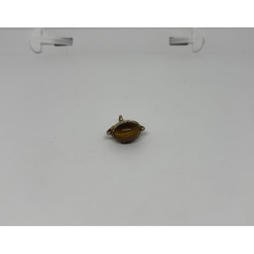 33 - 9ct Gold Albert charm featuring a tiger's eye, 5.5g - Only 10% buyer's premium