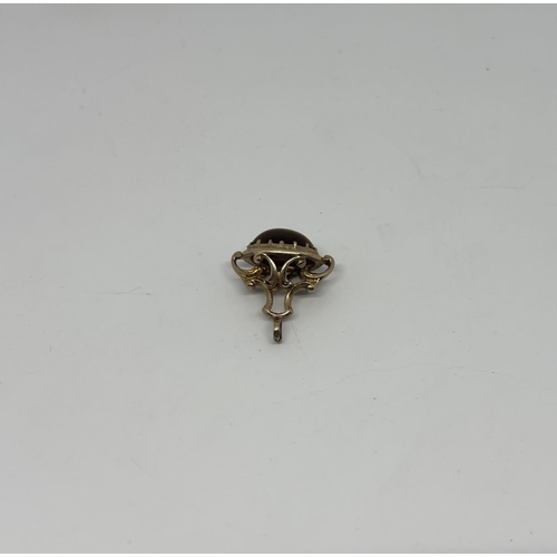 33 - 9ct Gold Albert charm featuring a tiger's eye, 5.5g - Only 10% buyer's premium