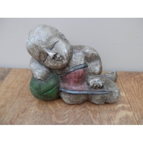 349 - A CARVED WOODEN ASIAN BOY SLEEPING ON A WATER MELON. FLAT BACKED 15cm tall and 20cm long