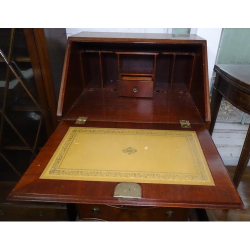 1106 - A reproduction cross-banded mahogany bureau of narrow size, with 4 serpentine-front drawers, on brac... 