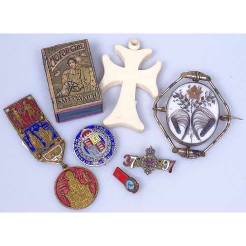 111 - A 19th century memoriam brooch with hair panel, an early matchbox, a cross, and badges