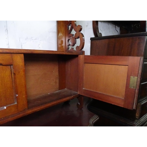 1111 - A Victorian mahogany hanging shelf with cupboard doors, and pierced scrolled sides, W61cm, H87cm