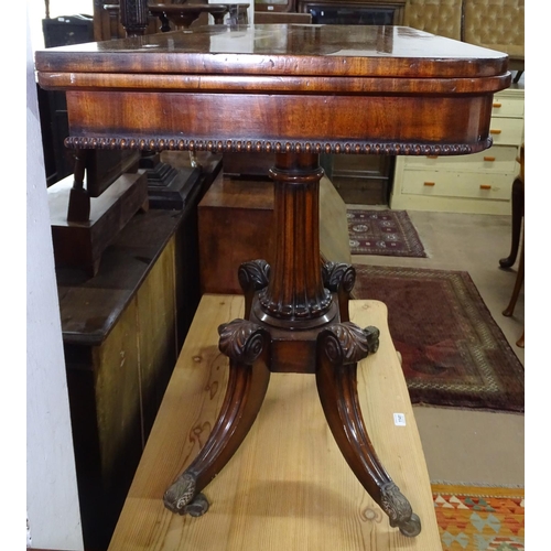 1140 - A Regency mahogany fold over card table, with tooled green leather interior, raised on a fluted cent... 