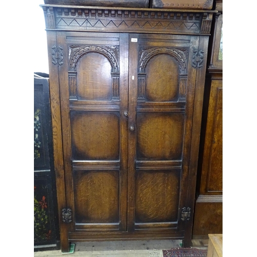 1150 - An Ipswich oak design hall cupboard, with 2 carved panelled doors, W110cm