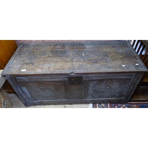 1223 - An 18th century joined oak coffer, with plank top and carved panelled front on stile legs, W127cm