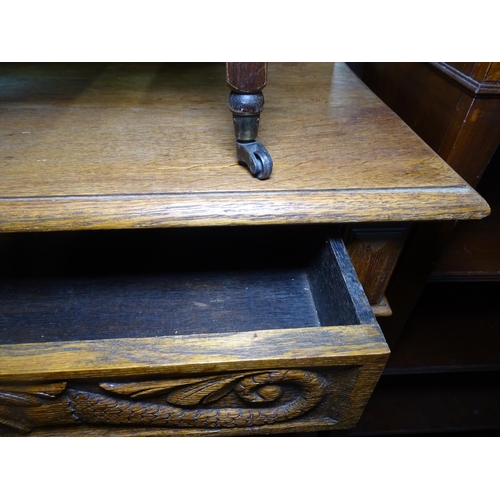 1265 - A 1920s oak side table with raised back, carved single frieze drawer on baluster turned legs, W91cm