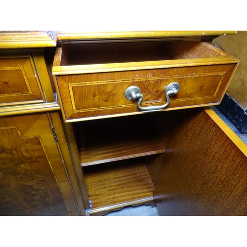 1268 - A reproduction yew wood break-front sideboard, with fitted drawers and cupboards, bears label for Br... 