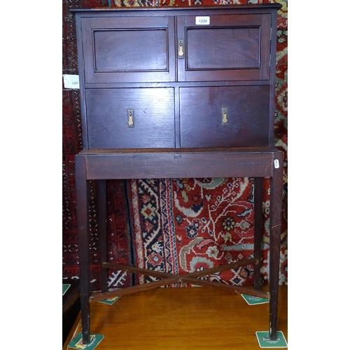 1296 - A 1920s panelled oak cabinet on stand, W61cm