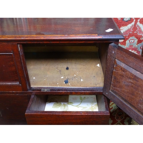 1296 - A 1920s panelled oak cabinet on stand, W61cm