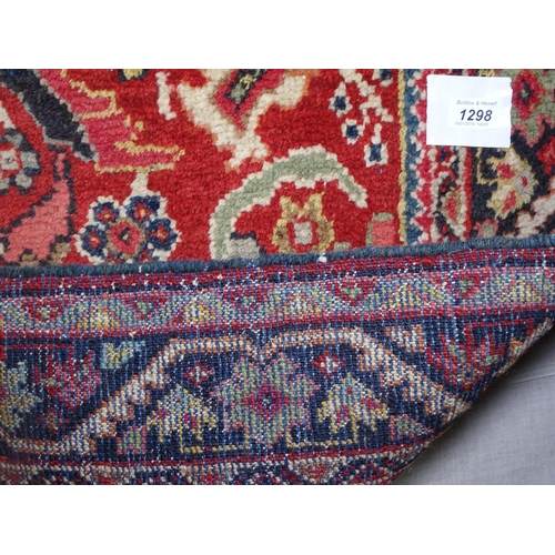 1298 - A red ground wool Persian design rug, 220cm x 130cm approx