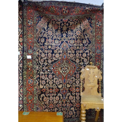 1299 - A black ground Persian wool rug, 210cm x 130cm approx