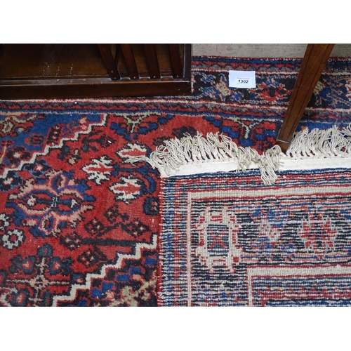 1302 - A blue ground Caucasian rug with symmetrical pattern, 190cm x 122cm