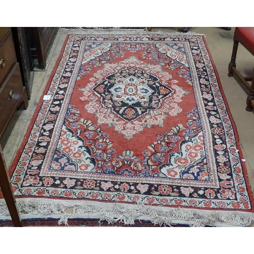 1303 - A red ground Tabriz design rug, 200cm x 135cm