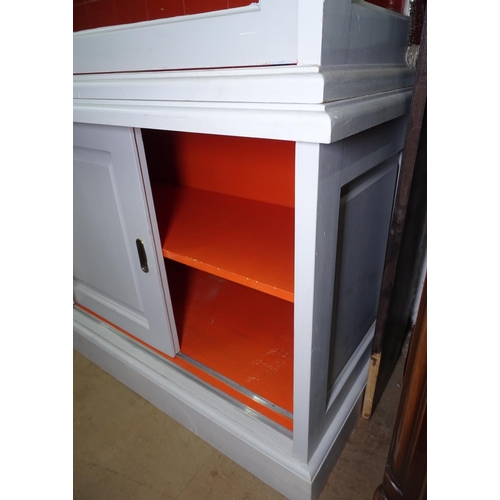 1322 - A large grey painted 2-section cabinet, the top fitted with sliding glazed doors, panelled sliding c... 