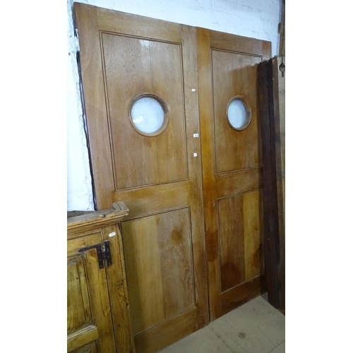 1325 - A pair of teak hotel internal doors, with bullseye glass panels, door size H211cm, W71cm