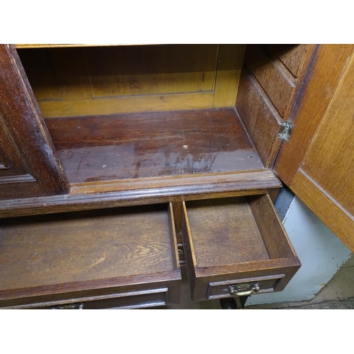 1350 - An Antique panelled oak cupboard on stand, 2 doors revealing adjustable shelves, stand fitted with 2... 