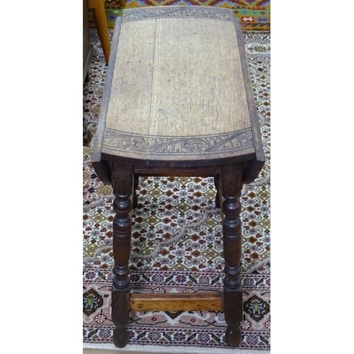 1390 - An oak drop leaf swivel-top occasional table, with carved decoration and baluster legs, W55cm