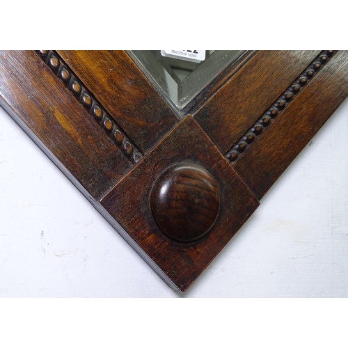 1422 - A 1920s carved oak and bevel edged wall mirror, W71cm