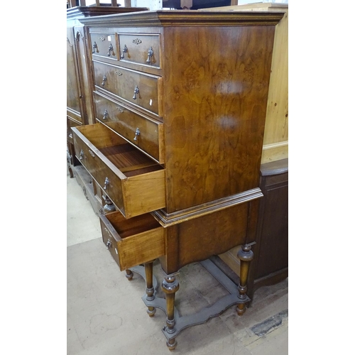 1438 - A walnut Queen Anne style chest on stand, top fitted with 2 short and 3 long drawers, the base fitte... 