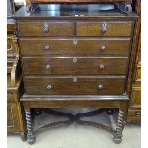 1444 - A 1920s oak chest on stand, top fitted with 2 short and 3 long drawers, stand raised on barley twist... 