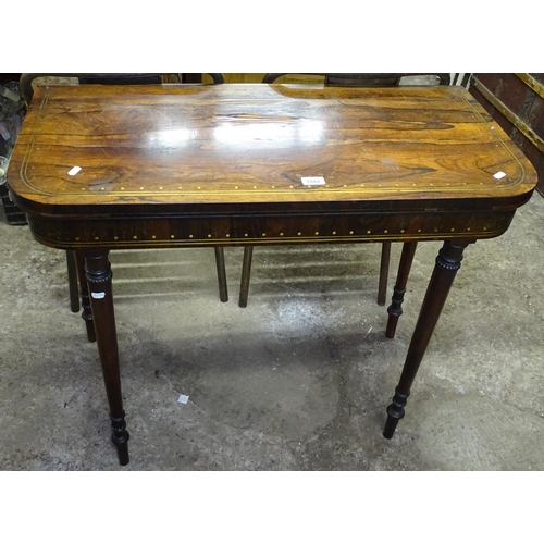 1582 - A Regency rosewood and brass inlaid fold over card table, raised on carved baluster legs, W91cm