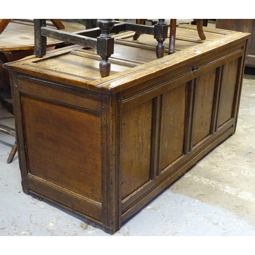 1620 - An 18th century joined oak coffer, with panelled front, on stile legs, W129cm