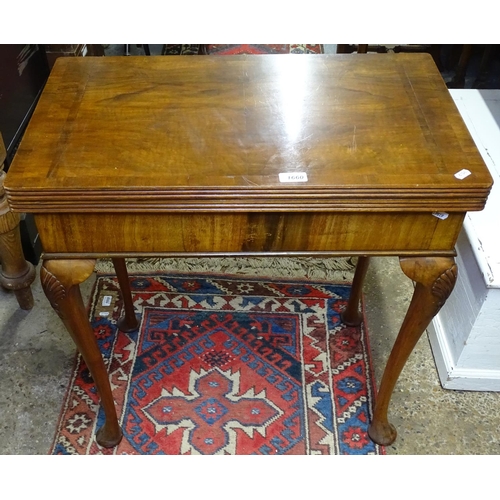 1660 - A 1930s cross-banded walnut rectangular fold over card table, on shell carved cabriole legs, W68cm