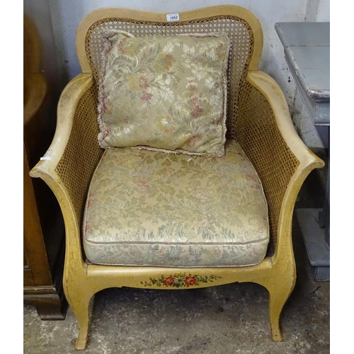 1662 - A Continental painted Bergere armchair, with single cane panels