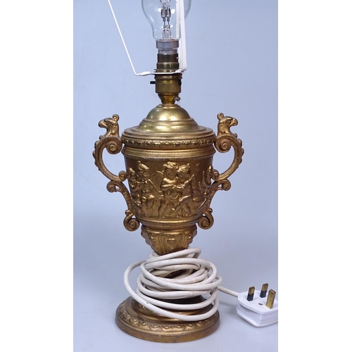 24 - A gilded metal table lamp with embossed cherubs frieze