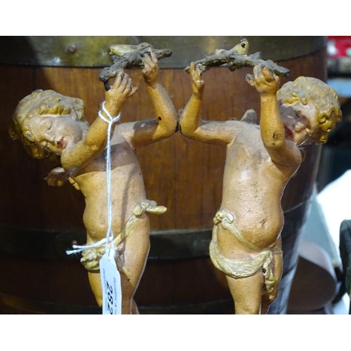 282 - A Continental embossed and painted metal clock, surmounted by 2 cherubs, height 14.5