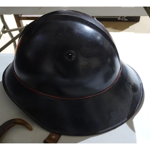 445 - A metal fireman's helmet with brass mounts, and another