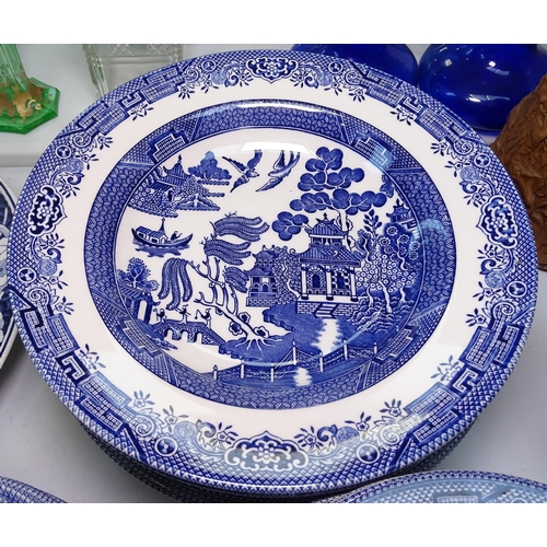 525 - A large quantity of Willow pattern dinnerware