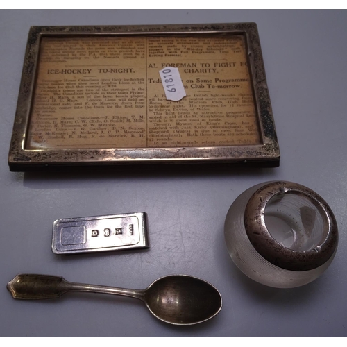 835 - A rectangular silver-fronted photo frame, a silver-mounted vesta, a money clip and a teaspoon