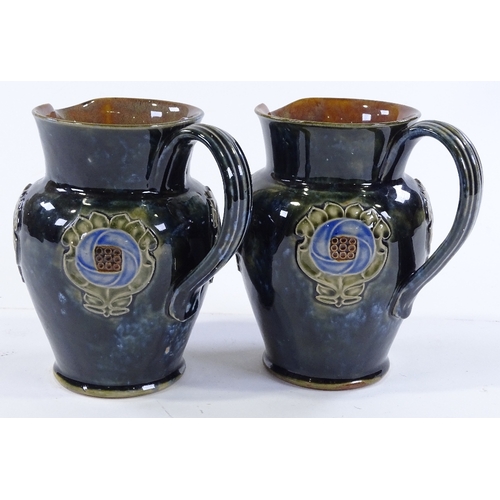 142 - A pair of Royal Doulton stoneware jugs, with relief moulded floral decoration, height 16cm