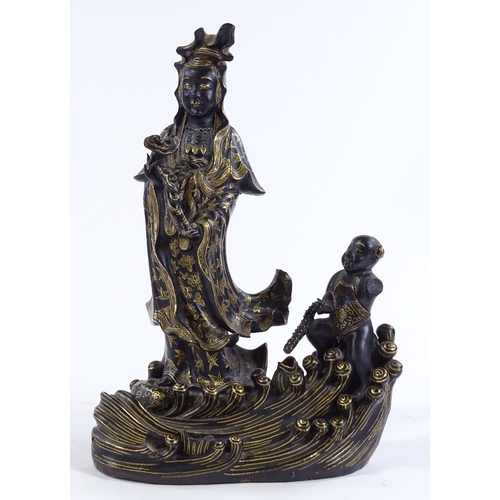 156 - A Chinese gilded and black glaze ceramic figure of Buddha, on wave design base, height 24cm